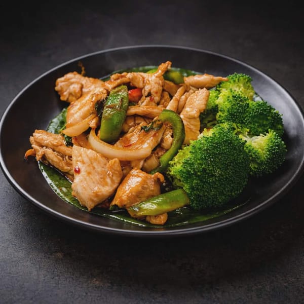 Chicken stir-fry with broccoli, green peppers, and onions in a black bowl.